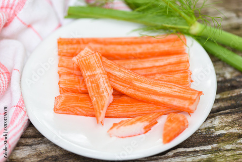 Crab sticks sliced on white plate and vegetable , Fresh crab sticks surimi ready to eat japanese food.