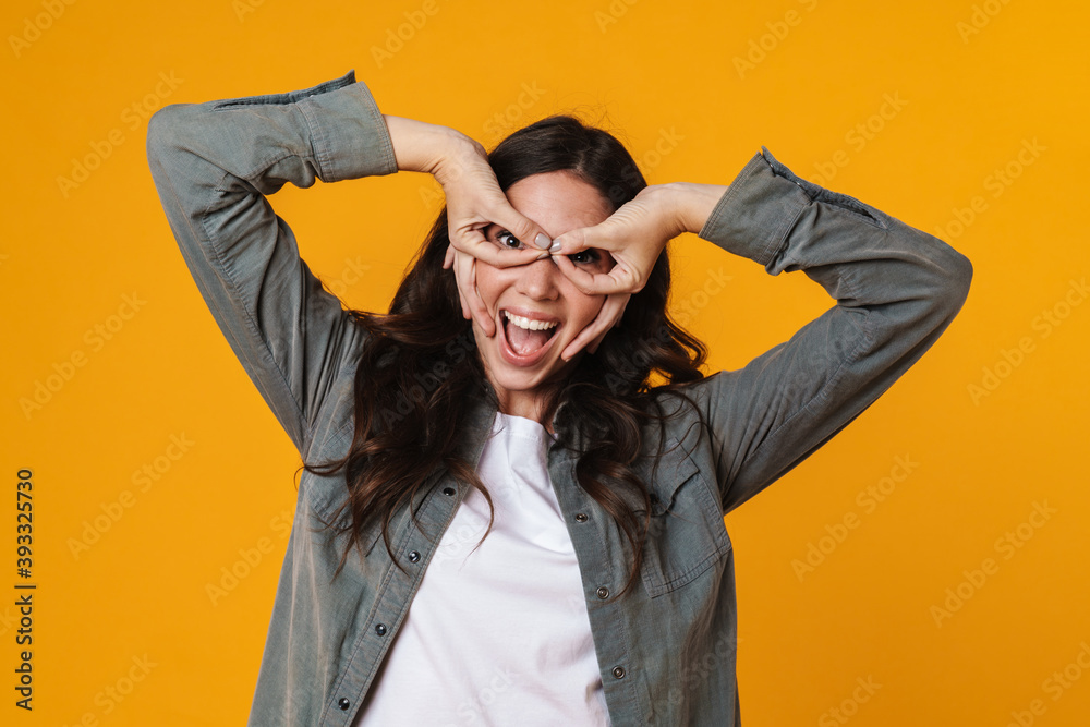 Joyful beautiful girl laughing and making glasses with fingers
