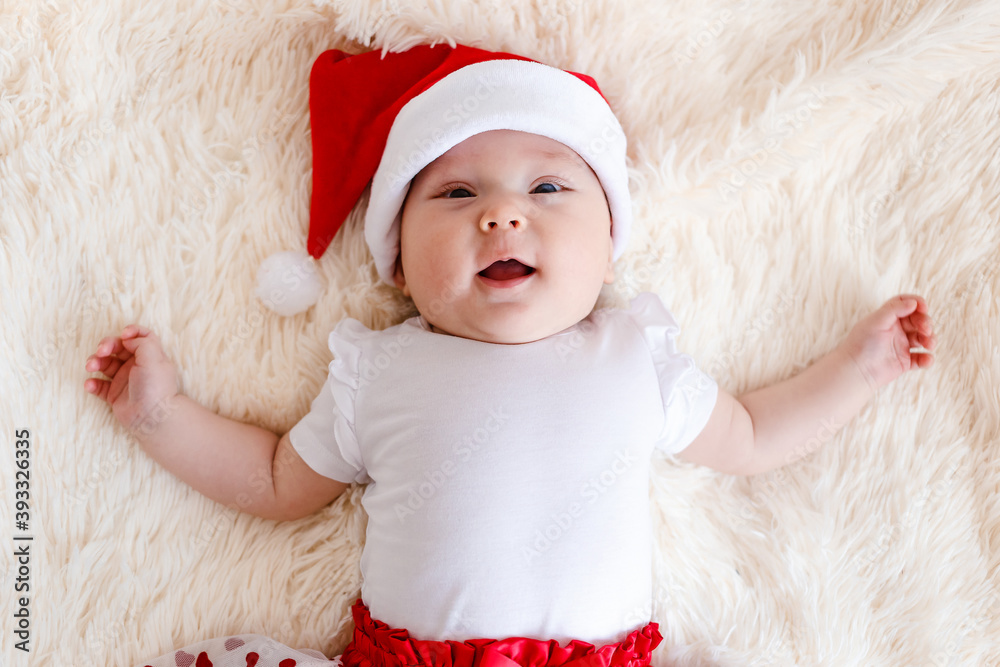 Portrait of a cute smiling five-month-old baby in santa cap. Merry Christmas. children for the new year Portrait of a cute smiling five-month-old baby in santa cap. Merry Christmas. children for the new year