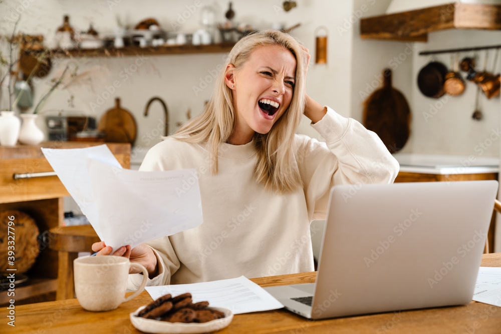 Beautiful shocked woman expressing surprise while working with laptop Beautiful shocked woman expressing surprise while working with laptop