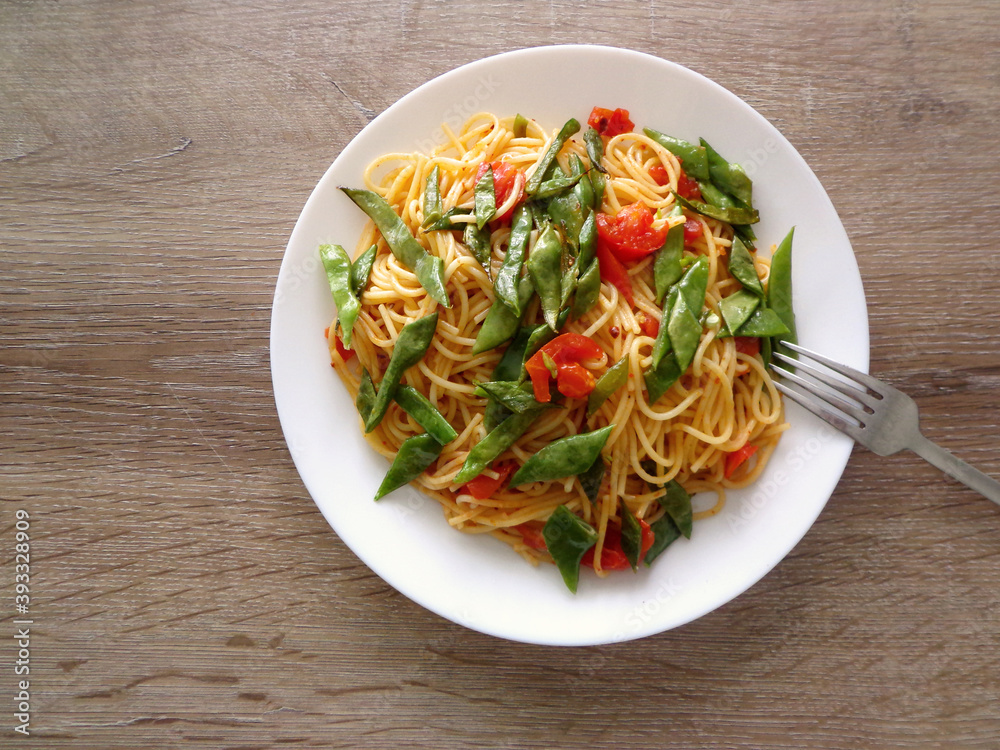 Spaghetti with roasted vegetables and sauce, top view