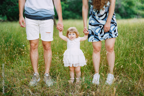 mother and father are holding daughter by the arms