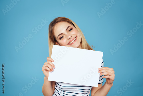 Woman holding sheet of paper striped T-shirt Copy Space cropped view blue background 