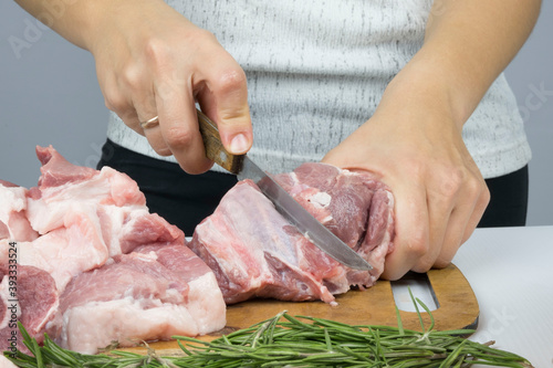 close up women's hands cut delicious, raw, fresh meat with a knife. cooking pork. cooking meat pork steaks