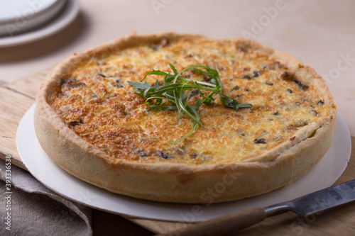Traditional French Quiche with cheese, spinach and chicken. Quiche lorraine. French cuisine. Top view. Light wooden background