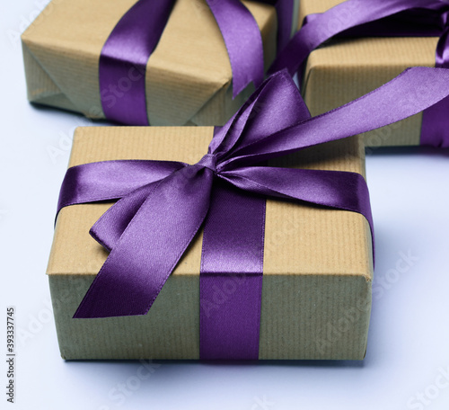 box wrapped in brown paper and tied with a purple silk ribbon