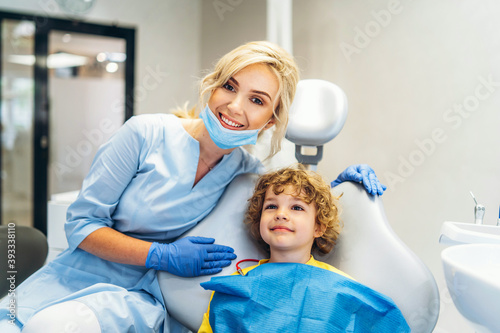 Cute young boy visiting dentist  having his teeth checked by female dentist in dental office.
