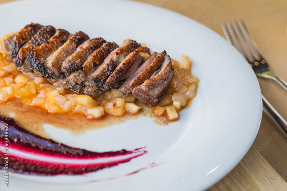 orange duck meal on the side. White plate. orange duck meal on the side. White plate.