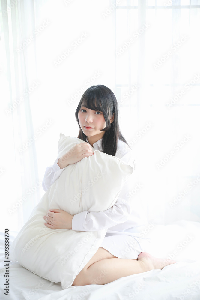 Portrait beautiful asian girl sitting with pillow at white bedroom Portrait beautiful asian girl sitting with pillow at white bedroom