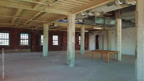 Interior view of an empty, unfinished office space that is under construction inside a large brick building. photo