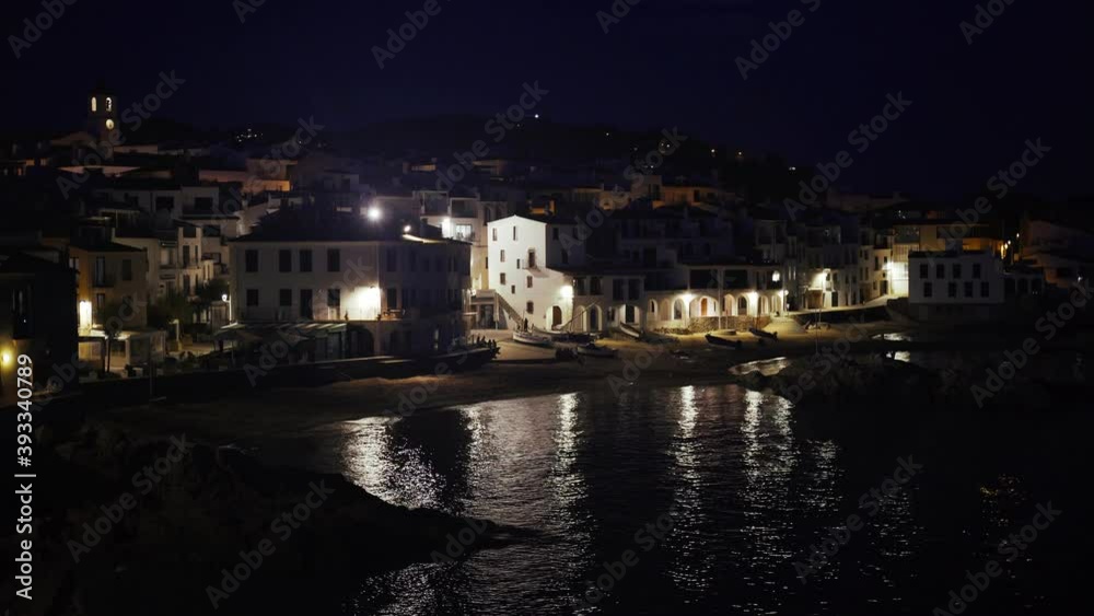 Beautiful Mediterranean village at evening. Night views on a small town on a sea coast. Water and lights of Calella de Palafrugell in Spain. Costa Brava vacation an chill. White houses on the beach.. Beautiful Mediterranean village at evening. Night views on a small town on a sea coast. Water and lights of Calella de Palafrugell in Spain. Costa Brava vacation an chill. White houses on the beach..