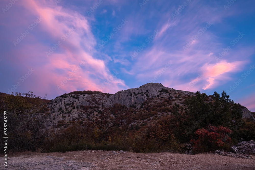 Pink clouds over mountains at sunrise