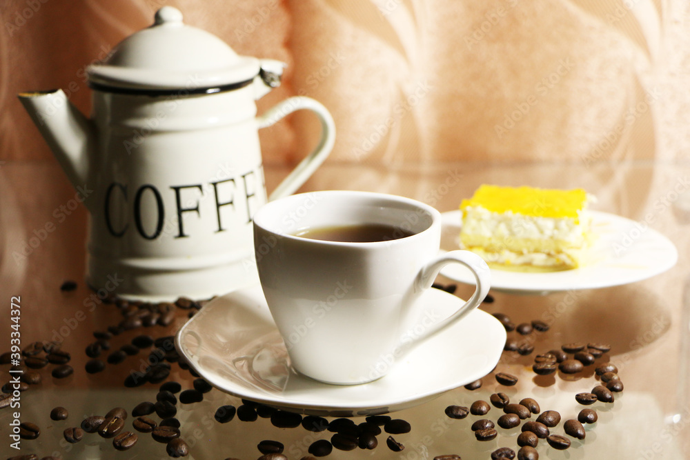 Cup of coffee and coffee beans on a glass table. The concept of home comfort and warmth. Cup of coffee and coffee beans on a glass table. The concept of home comfort and warmth.