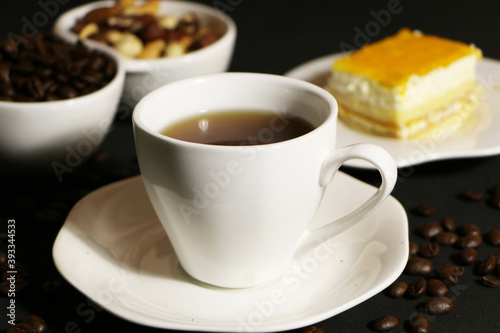 A cup of coffee with milk and coffee beans on a glass table. The concept of home comfort and warmth.