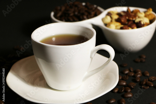 A cup of coffee with milk and coffee beans on a glass table. The concept of home comfort and warmth.