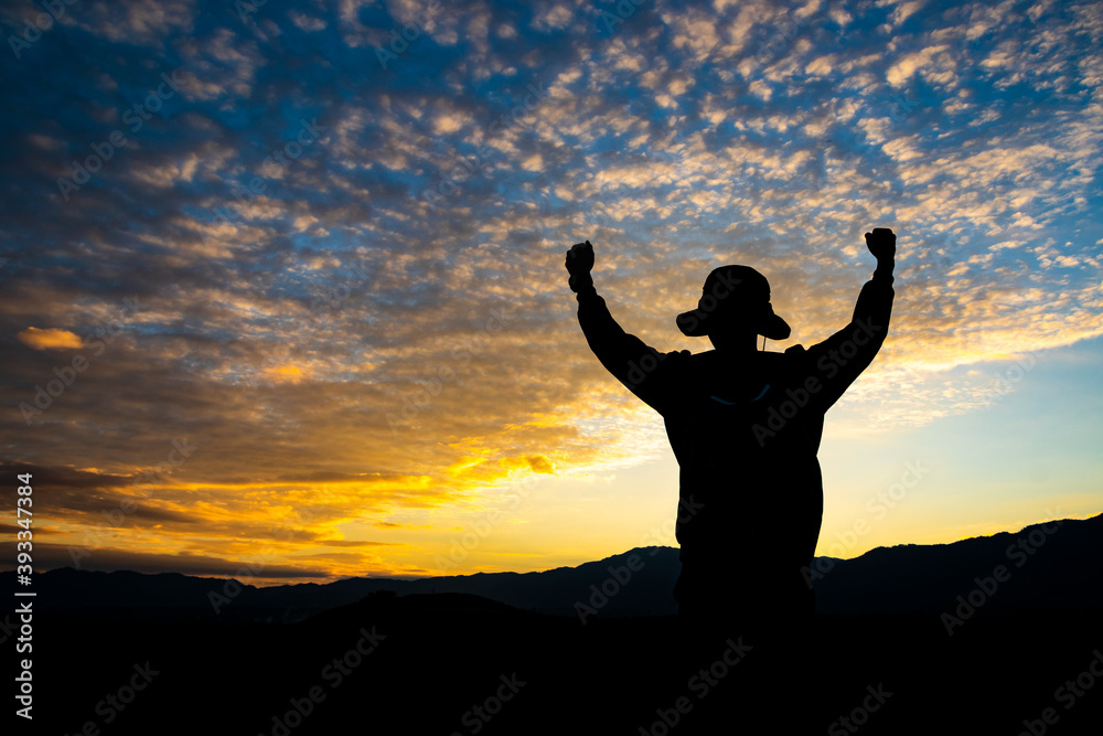 Man with arms extended toward heaven at sunrise ,success or prayer concept