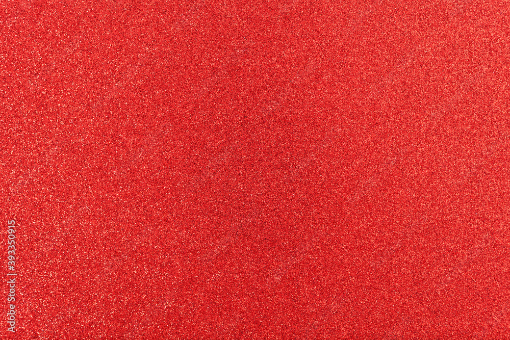Shiny surface. Red glitter texture. Christmas abstract background, defocused