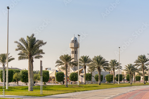 A common small mosque with palm tree in the Dammam Corniche coastal park in Dammam, Kingdom of Saudi Arabia photo
