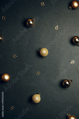 Christmas background with toys. Christmas gold ornaments on a black background. Flat layout, top view, copy space.