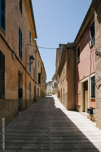 Fototapeta Naklejka Na Ścianę i Meble -  view of ground narrow street lane alley between houses with beautiful colours during summer in mallorca majorca