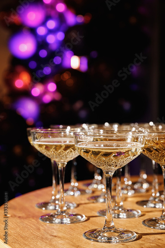 Glasses with Sparkling Wine. champagne glasses over Holiday Bokeh Blinking background. Celebration, party concept.