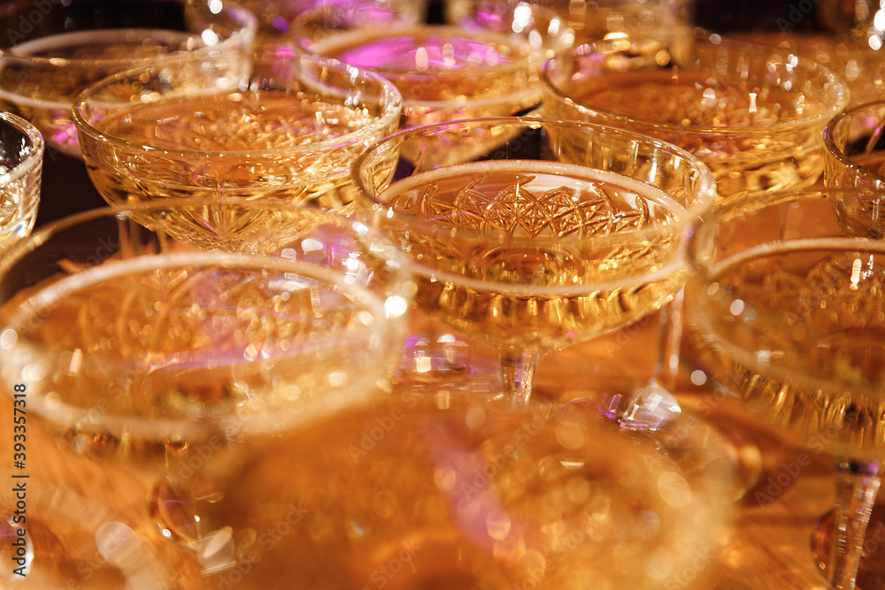 Glasses with Sparkling Wine. champagne glasses over Holiday Bokeh Blinking background. Celebration, party concept.