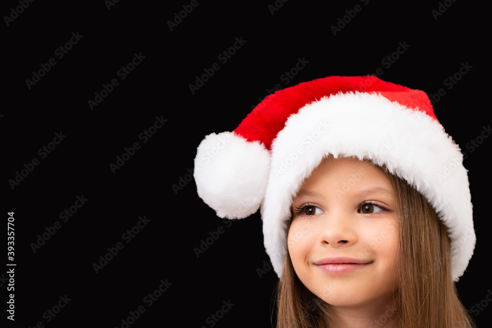 A cute little girl in a Christmas hat is smiling. A cute little girl in a Christmas hat is smiling.