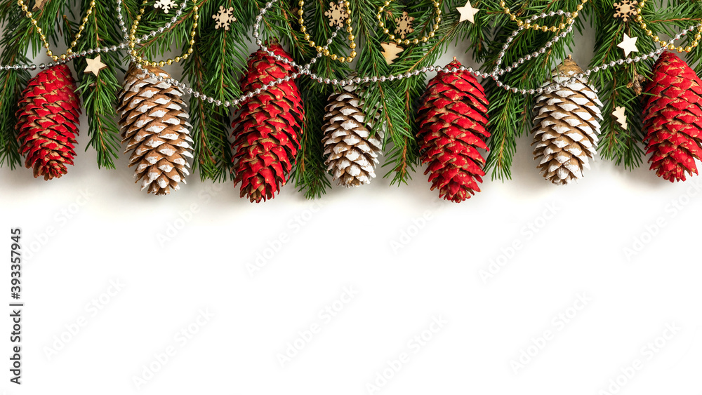 Fototapeta premium Fir branches, cones, and ornaments stand against an isolated background.