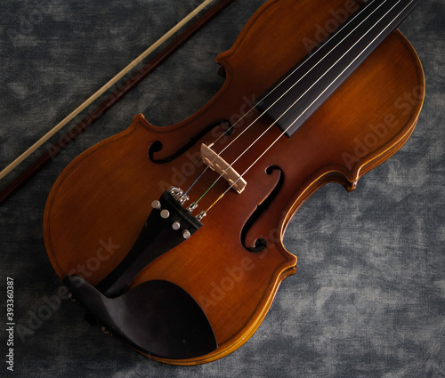 Violin front side put beside bow on background,