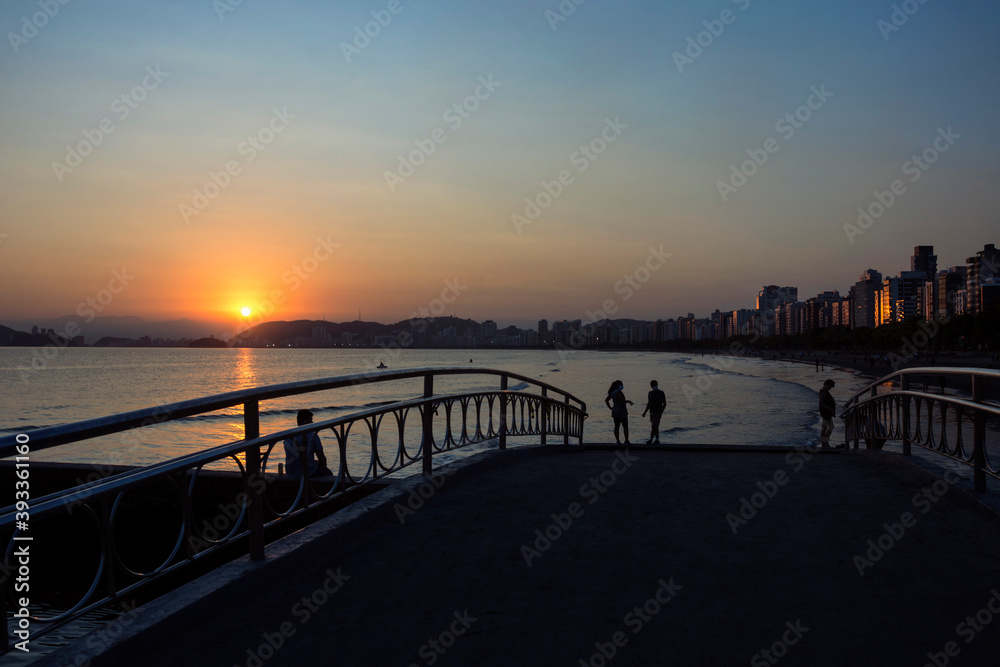 Sunset view at Santos beach, Canal 6, bridge and buildings on the waterfront.