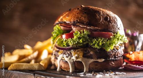 Classic beef burger with cheese cheddar bacon wegetable and french fries photo