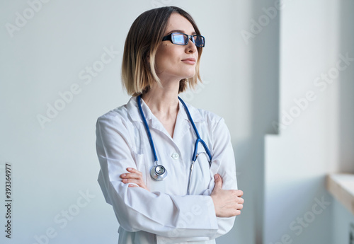 professional doctor woman with glasses near window and stethoscope
