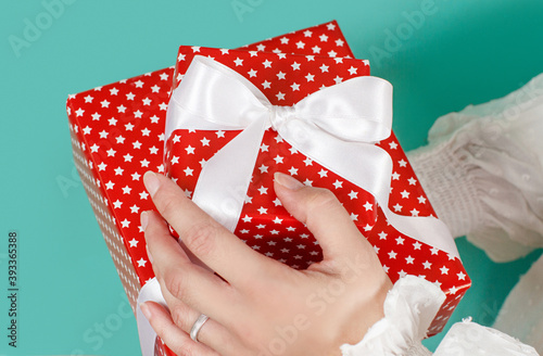 Hands holding wrapped presents on green