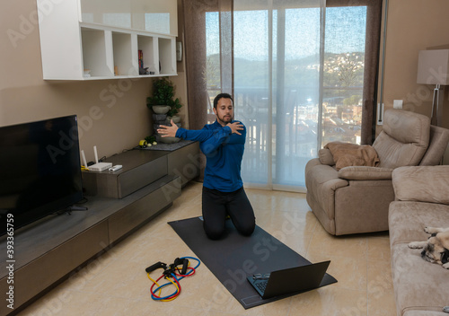 Latin man, doing a workout in his living room with a rubber band