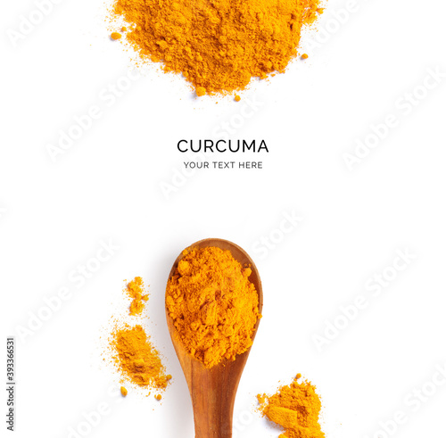 Fototapeta Naklejka Na Ścianę i Meble -  Creative layout made of turmeric powder and wood spoon on a white background. Top view.  
