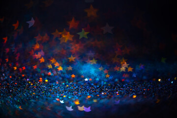 Festive twinkle lights background, abstract sparkle backdrop with stars, modern design overlay with sparkling glimmers. Blue, orange and green backdrop glittering sparks with blur effect
