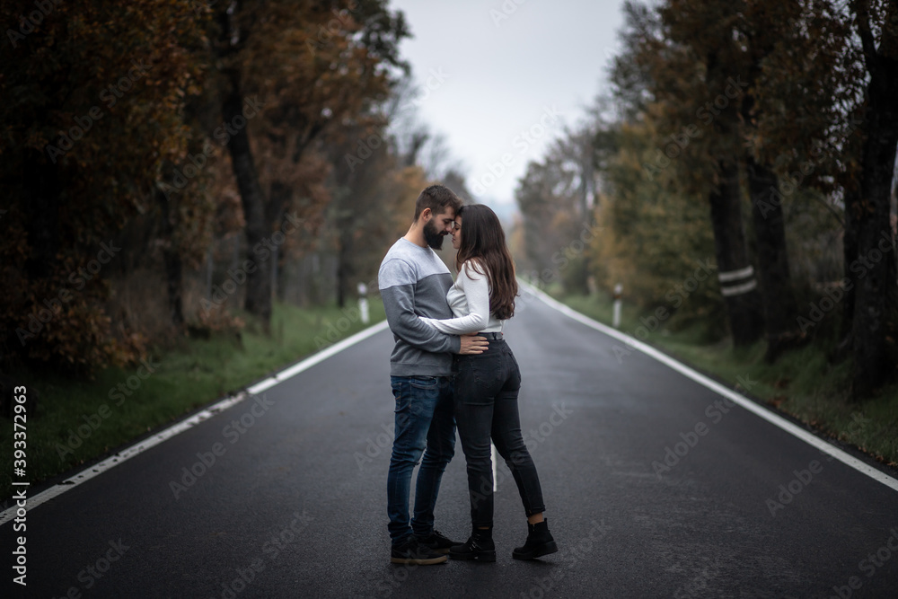 Beautiful portrait of young couple hugging while sitting on a perfect clean long road between the green forest in autumn
Beautiful portrait of young couple hugging while sitting on a perfect clean long road between the green forest in autumn