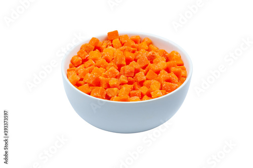 Top view of frozen diced carrots in a bowl on white background, close up