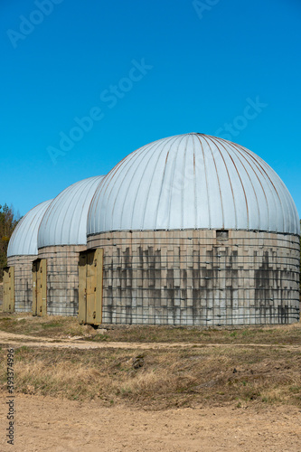 silver silos on agro manufacturing plant for processing drying cleaning and storage of agricultural products, flour, cereals and grain. Large iron barrels of grain. Granary elevator © Pokoman