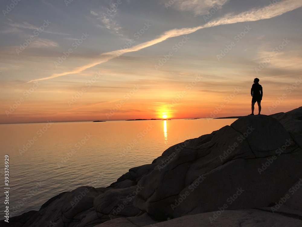 coucher de soleil avec une personne sur le côté droit qui regarde le paysage