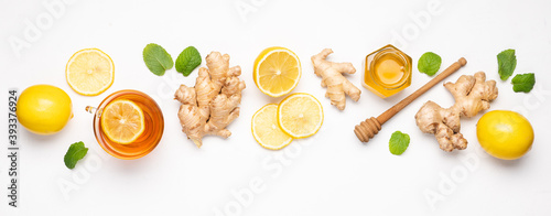 Hot tea with ginger, honey and lemon in glass cup. Immune system support with alternative medicine. White background, Top view, Сopy space