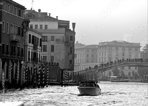 Venice, Italy, December 28, 2018 evocative black and white image of typical Venice canal with motorboat in motion
 photo