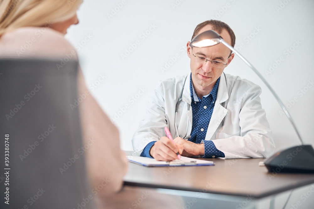 Woman sitting before the physician in his office Woman sitting before the physician in his office