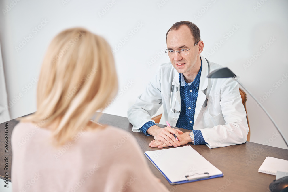 General practitioner looking at a female patient General practitioner looking at a female patient