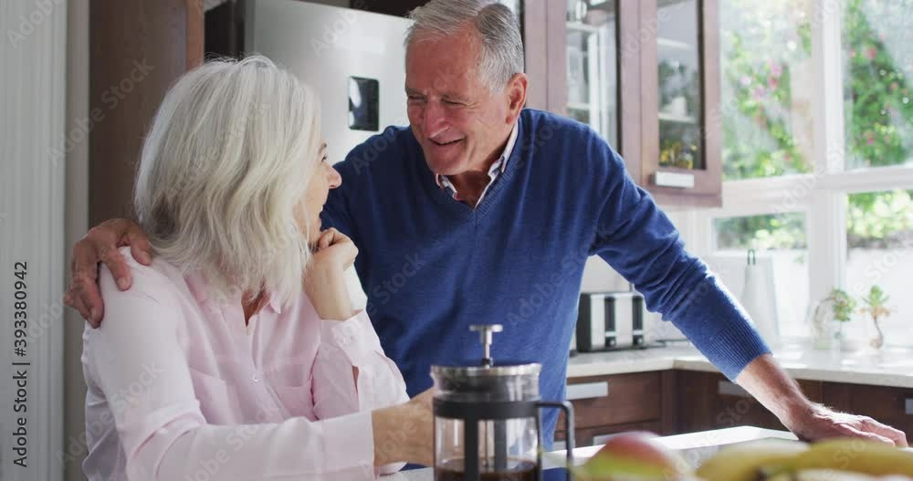 Happy senior couple embracing each other in the kitchen at home Happy senior couple embracing each other in the kitchen at home