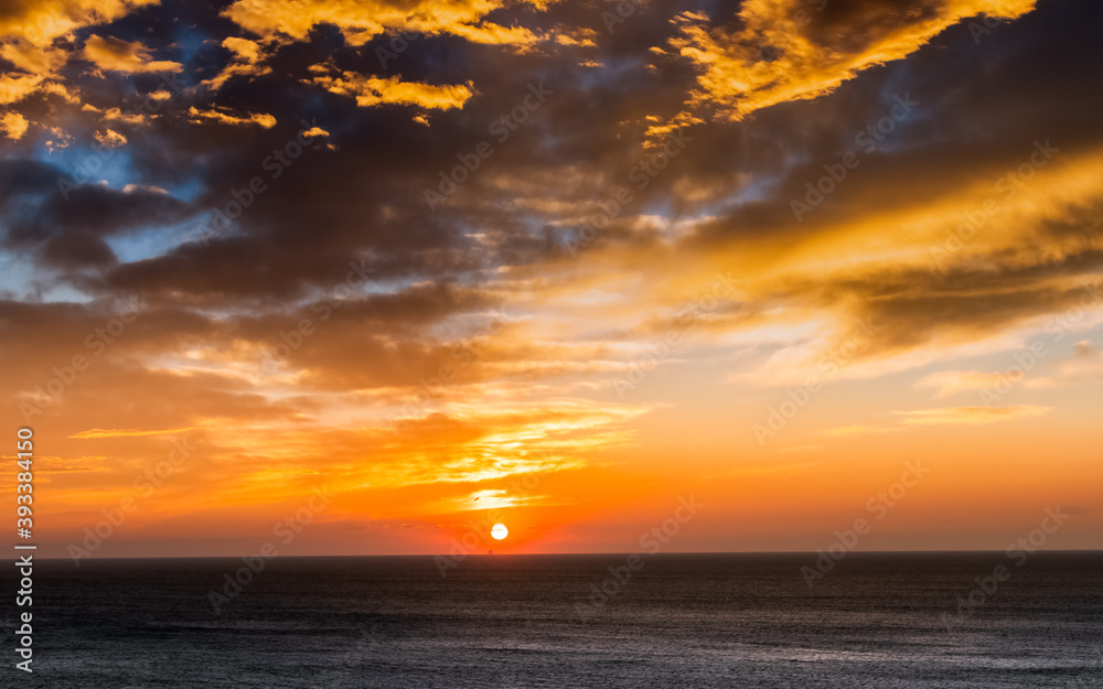 Vue d'un coucher de soleil depuis le poste de commandement d'un navire de croisière en navigation en pleine mer.	