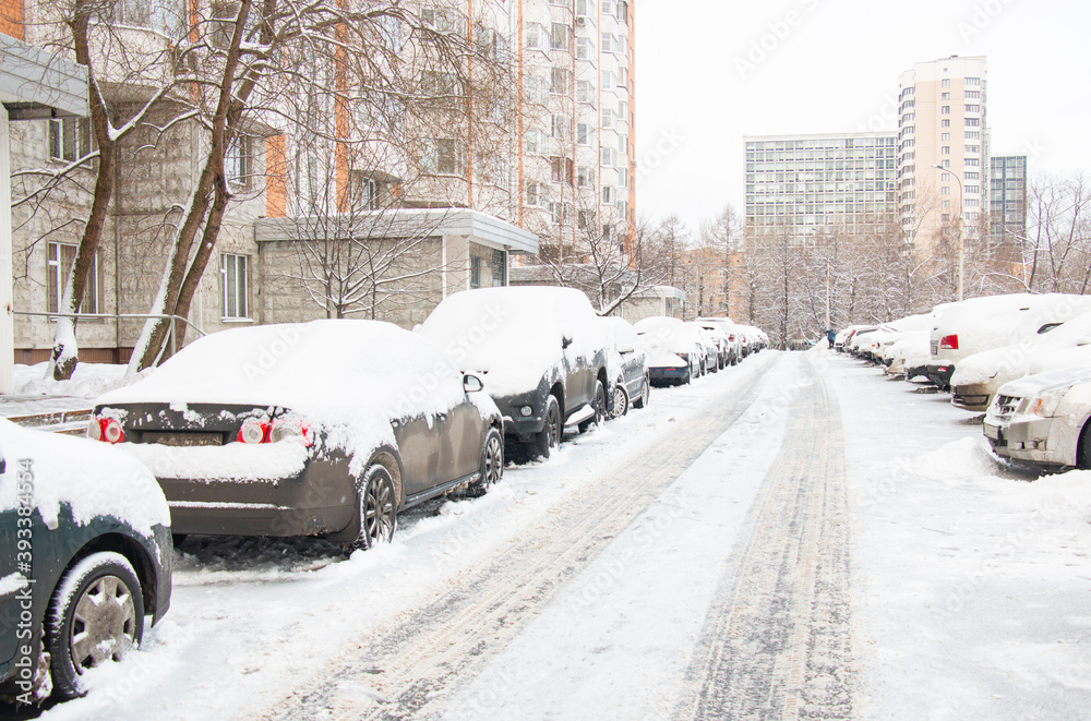 Snow-covered cars in the city after a snowfall Snow-covered cars in the city after a snowfall