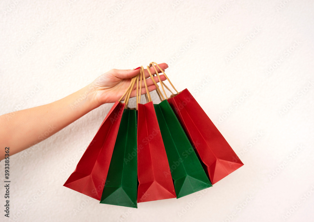 A woman holds two colorful crafted paper bags for shopping
