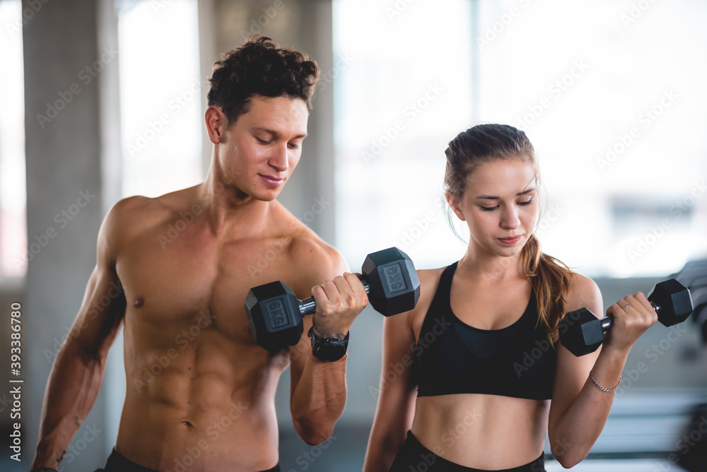 beautiful girl and her well-built boyfriend trainer, They are happy to see each othr in the gym. Young people are ready to start their workout