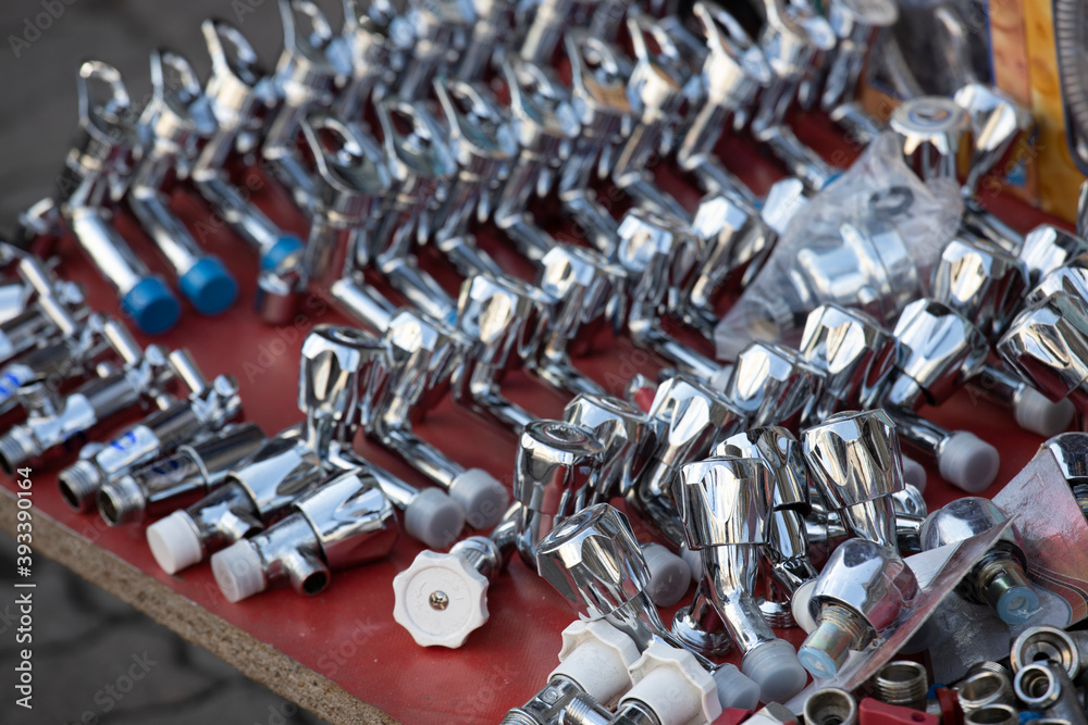 Obraz premium New faucets and shut-off equipment on the bench outside.